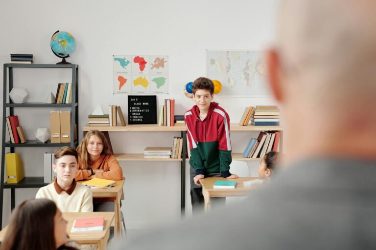 Students attentively listening in a classroom environment, promoting learning and engagement.